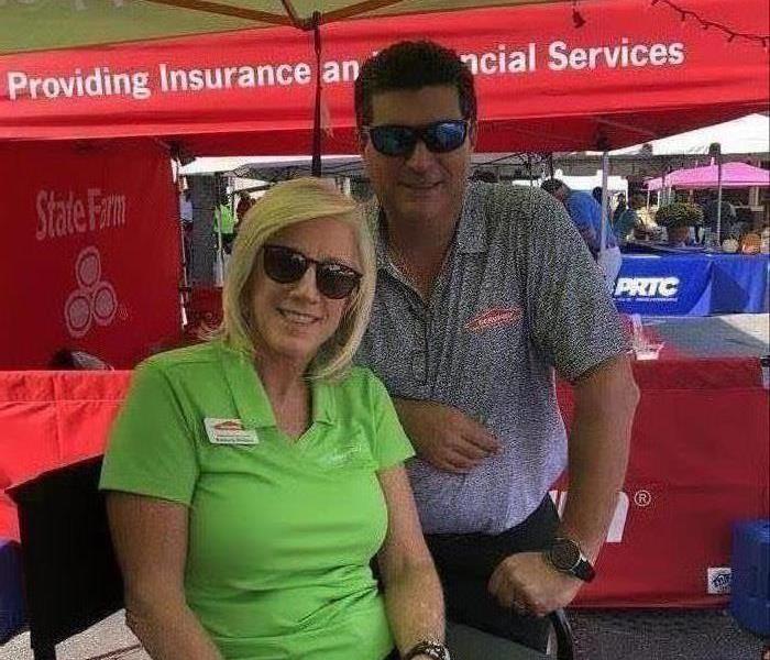 mand and woman working the SERVPRO tent at the 19th Annual Squealin on the Square