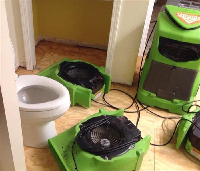 Air dryers drying out a residential bathroom after a water supply line burst. 