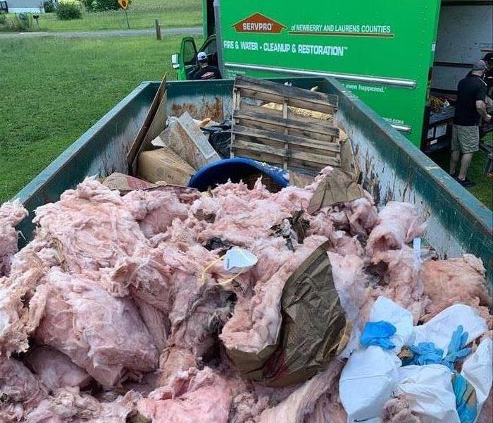 Dumpster full of wet insulation from water damage 