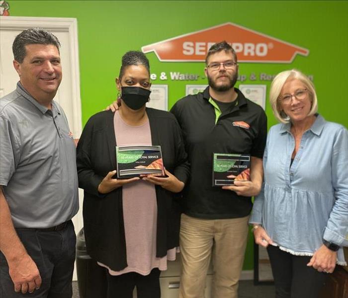 SERVPRO Owners and employees showing off their 10 year awards