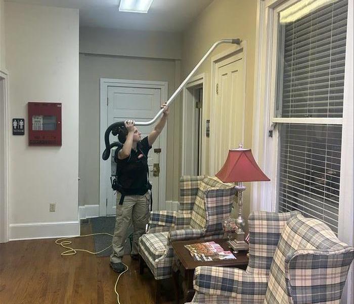 SERVPRO team cleaning over the doors with a vacuum 